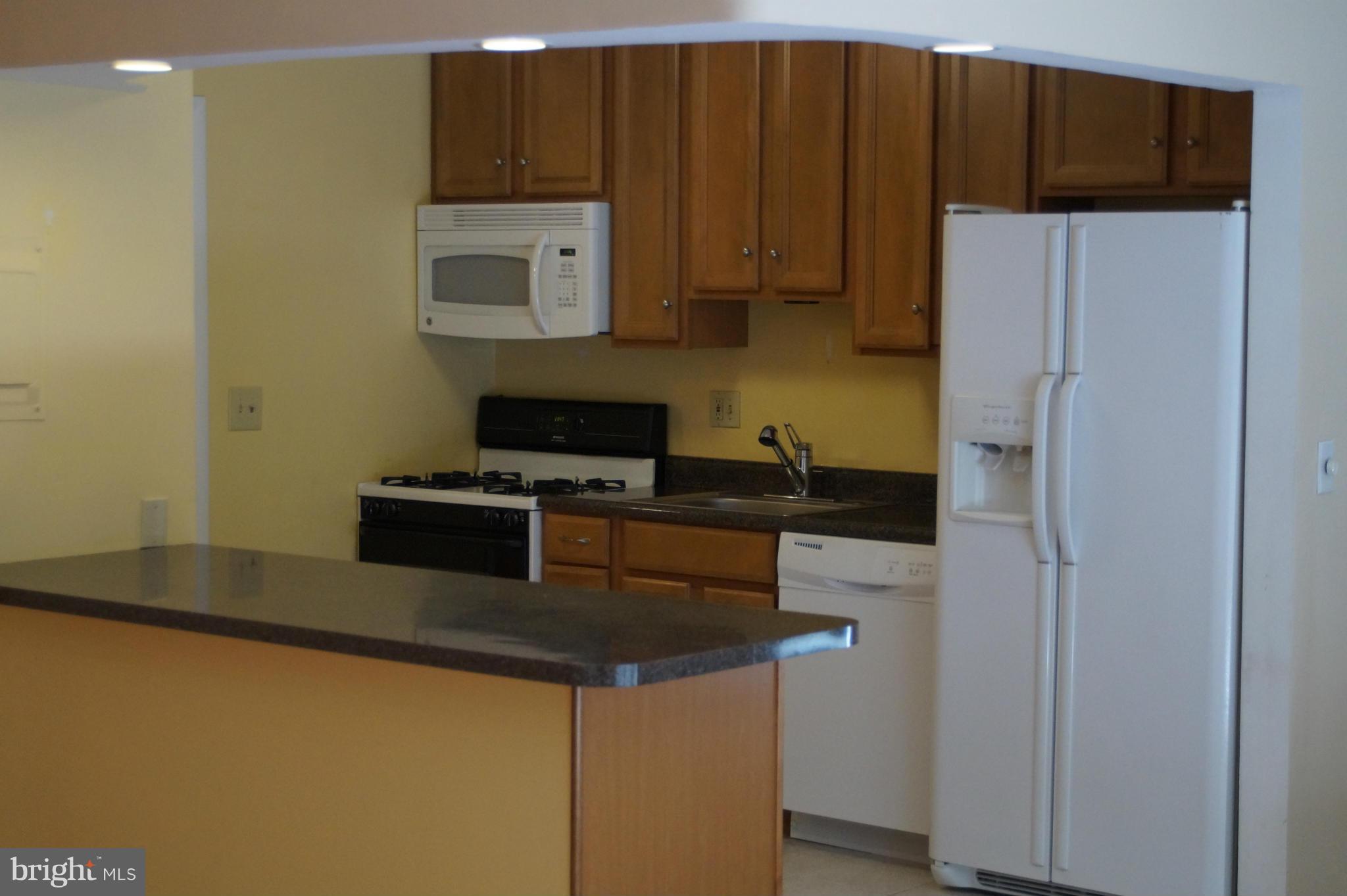 109 Cross Keys Road, Unit R109F Baltimore, MD 21210 - Photo 3 of 13 a kitchen with a refrigerator and a stove top oven