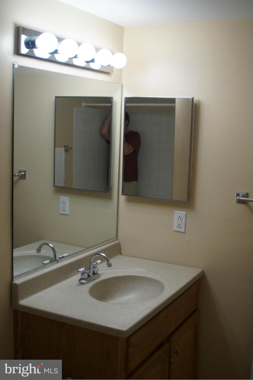 109 Cross Keys Road, Unit R109F Baltimore, MD 21210 - Photo 9 of 13 a bathroom with a sink and a mirror