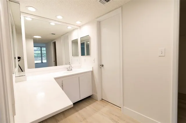 a large white bathroom with a sink and mirror