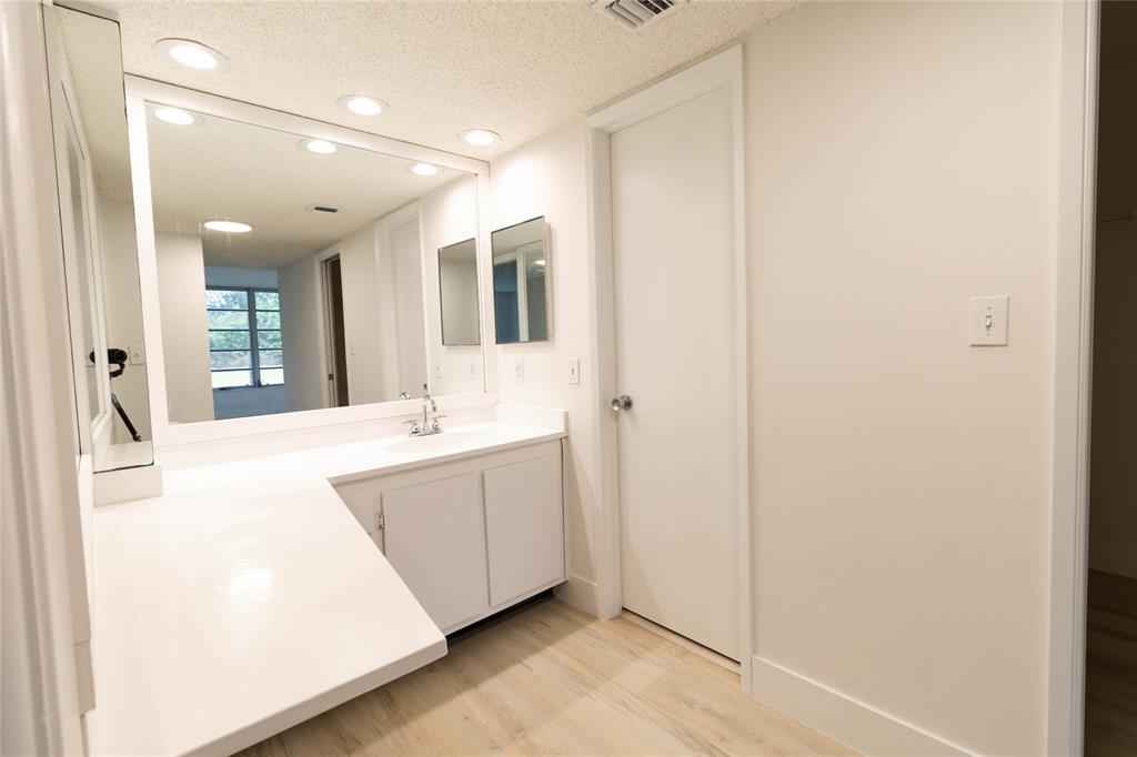 4007 North Cypress Drive, Unit 103 Pompano Beach, FL 33069 - Photo 23 of 25 a large white bathroom with a sink and mirror