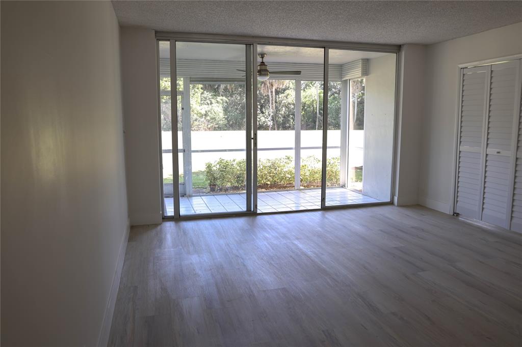 4007 North Cypress Drive, Unit 103 Pompano Beach, FL 33069 - Photo 5 of 25 wooden floor in an empty room with a window