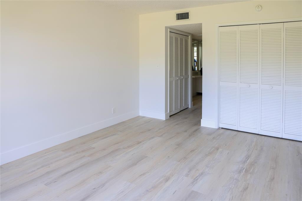 4007 North Cypress Drive, Unit 103 Pompano Beach, FL 33069 - Photo 10 of 25 an empty room with wooden floor and closet
