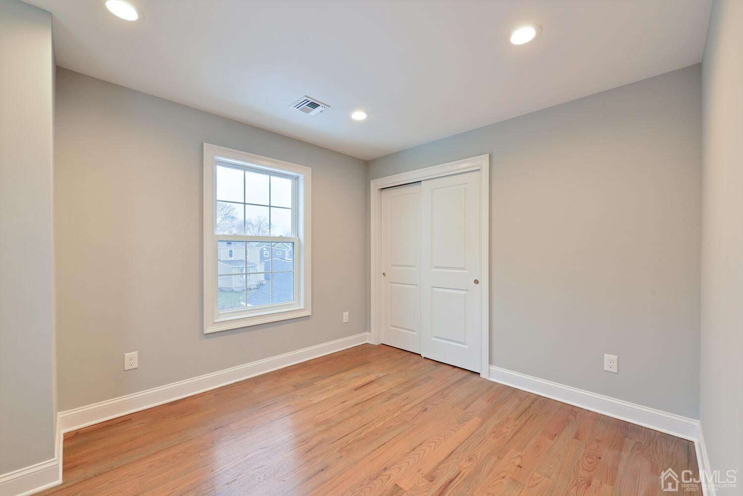 20 Sunset Drive Clark, NJ 07066 - Photo 20 of 32 an empty room with wooden floor and windows