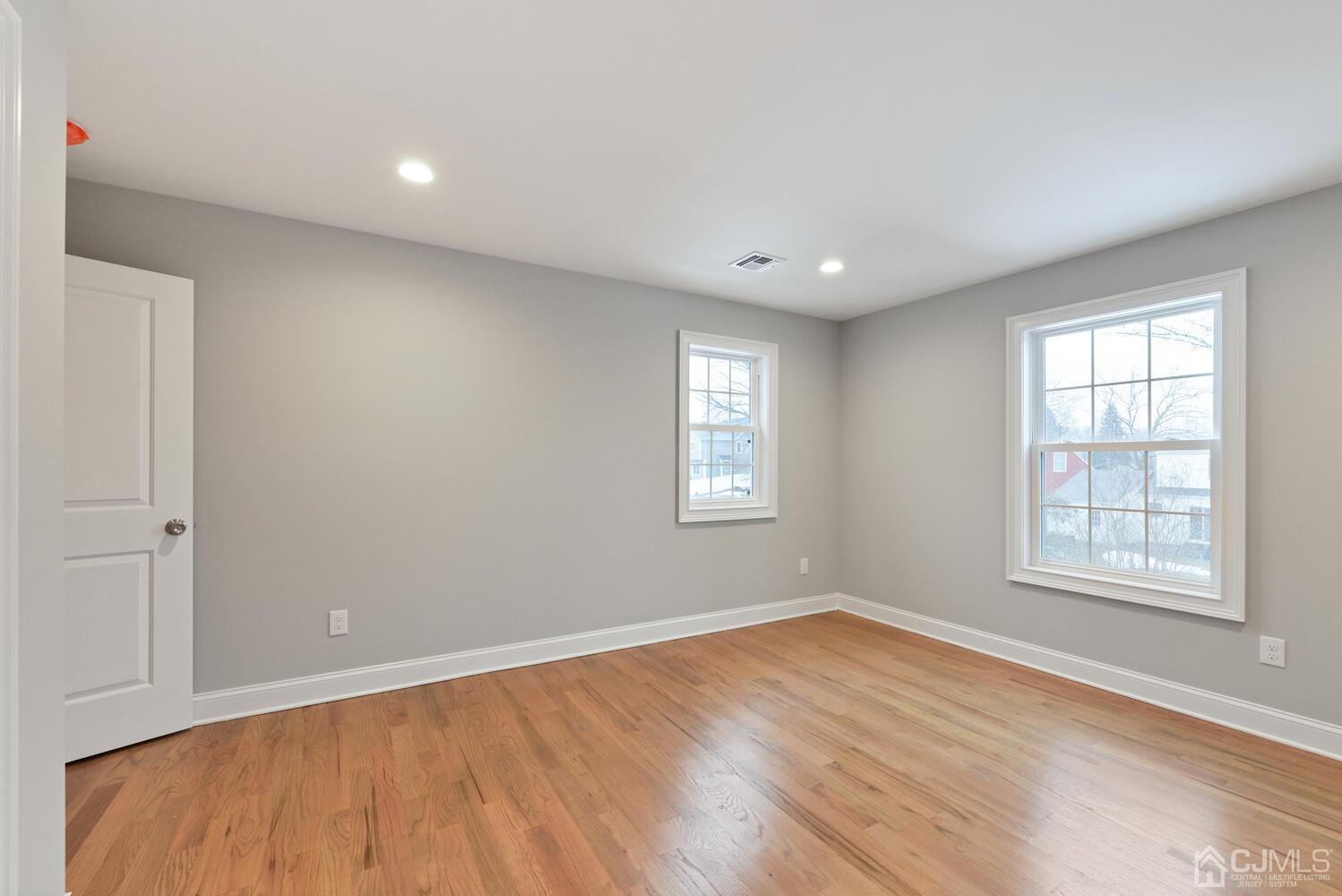 20 Sunset Drive Clark, NJ 07066 - Photo 23 of 32 an empty room with wooden floor and windows