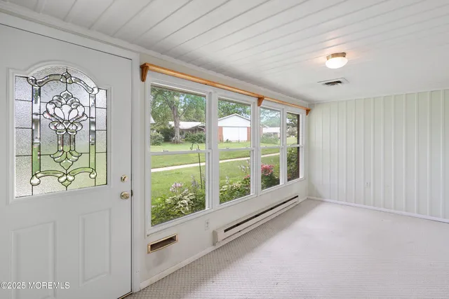 a view of an empty room with window and cabinet