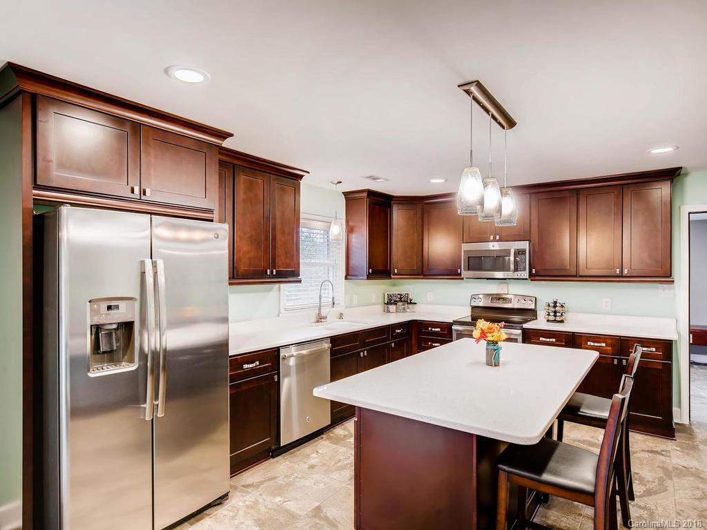 a kitchen with stainless steel appliances a sink stove refrigerator and cabinets