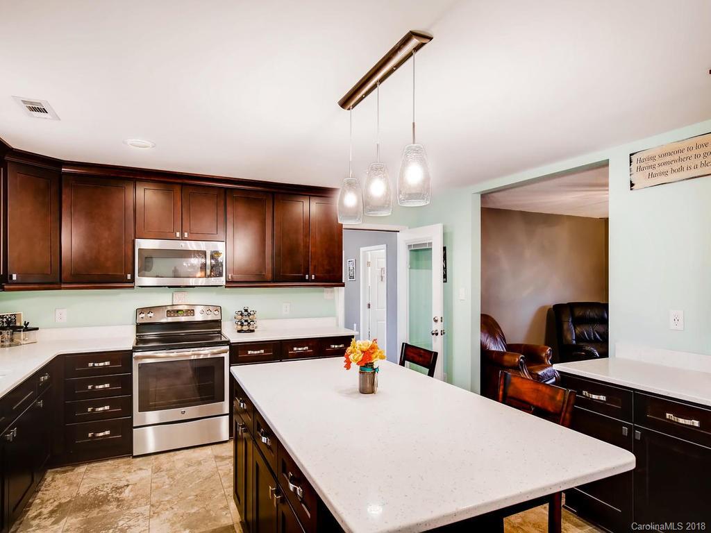 2411 Medlin Road Monroe, NC 28112 - Photo 13 of 27 a kitchen with a sink a stove and chairs