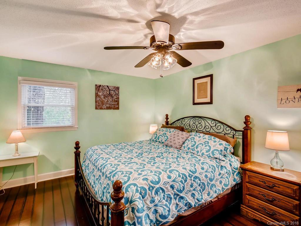 2411 Medlin Road Monroe, NC 28112 - Photo 16 of 27 a bedroom with a bed and wooden floor