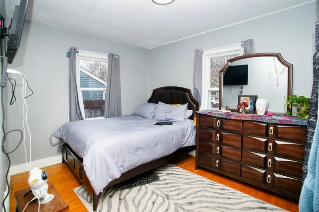a bedroom with a bed and a flat tv screen on dresser
