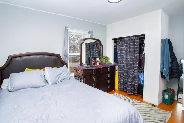 a bedroom with bed and a flat tv screen on dresser