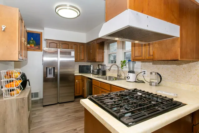 a kitchen with stainless steel appliances granite countertop a stove a sink and a refrigerator