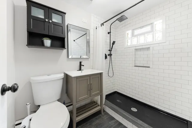a bathroom with a toilet sink and mirror
