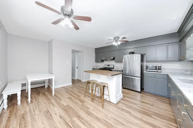 a kitchen with refrigerator cabinets and wooden floor