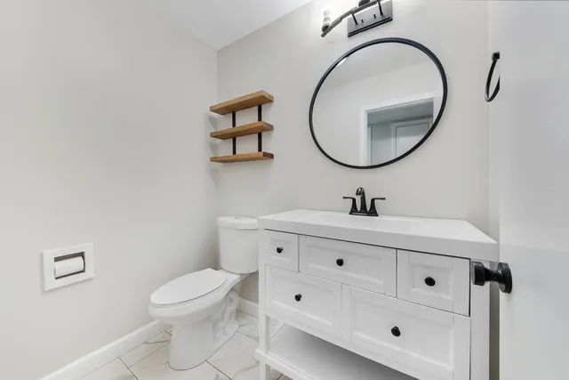 a bathroom with a toilet a sink a mirror and a shower