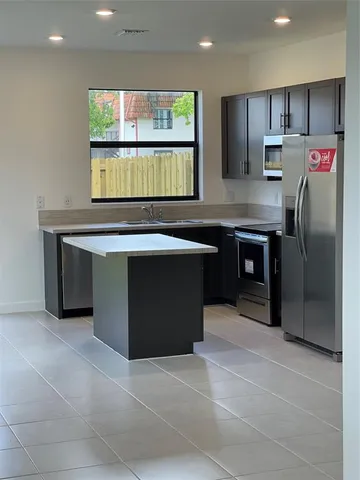 a kitchen with stainless steel appliances granite countertop a refrigerator and a sink