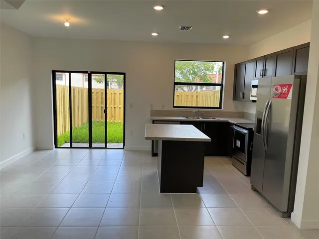 a kitchen with stainless steel appliances granite countertop a refrigerator and a sink