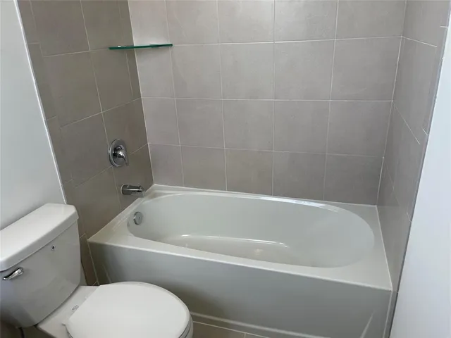 a white bath tub sitting next to a white toilet and a sink