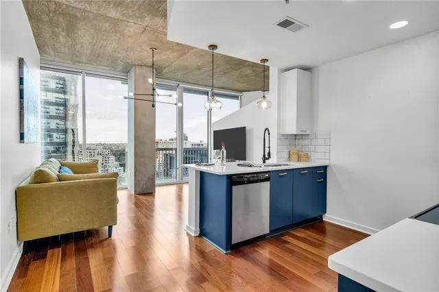 a large kitchen with stainless steel appliances a stove and a large window