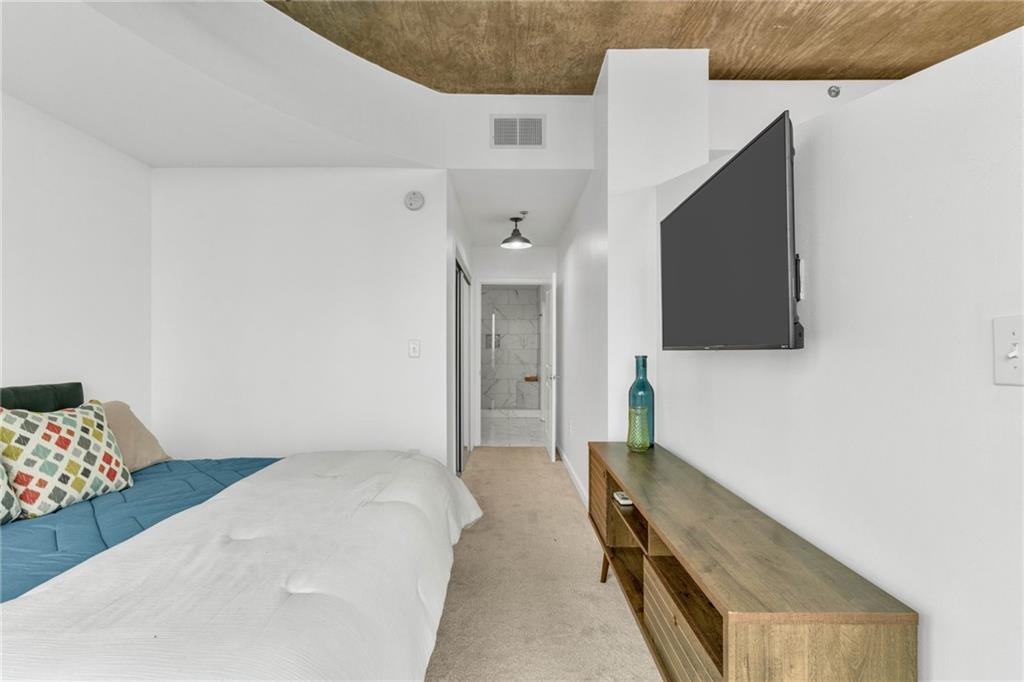 3324 Peachtree Road Northeast, Unit 1813 Atlanta, GA 30326 - Photo 13 of 34 a bedroom with a bed and a lamp on dresser