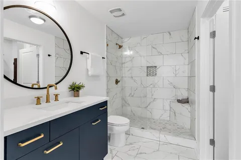 a bathroom with a sink a toilet and shower