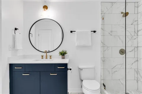 a bathroom with a sink a mirror a toilet and a mirror