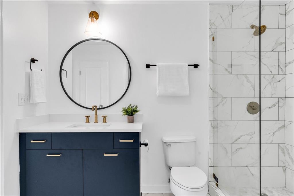 3324 Peachtree Road Northeast, Unit 1813 Atlanta, GA 30326 - Photo 16 of 34 a bathroom with a sink a mirror a toilet and a mirror
