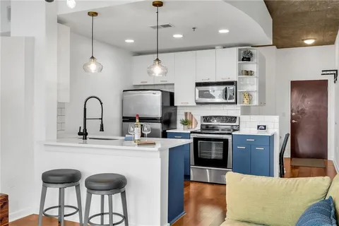 a kitchen with stainless steel appliances granite countertop a stove a sink a refrigerator and a microwave