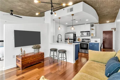 a living room with furniture kitchen view and a flat screen tv