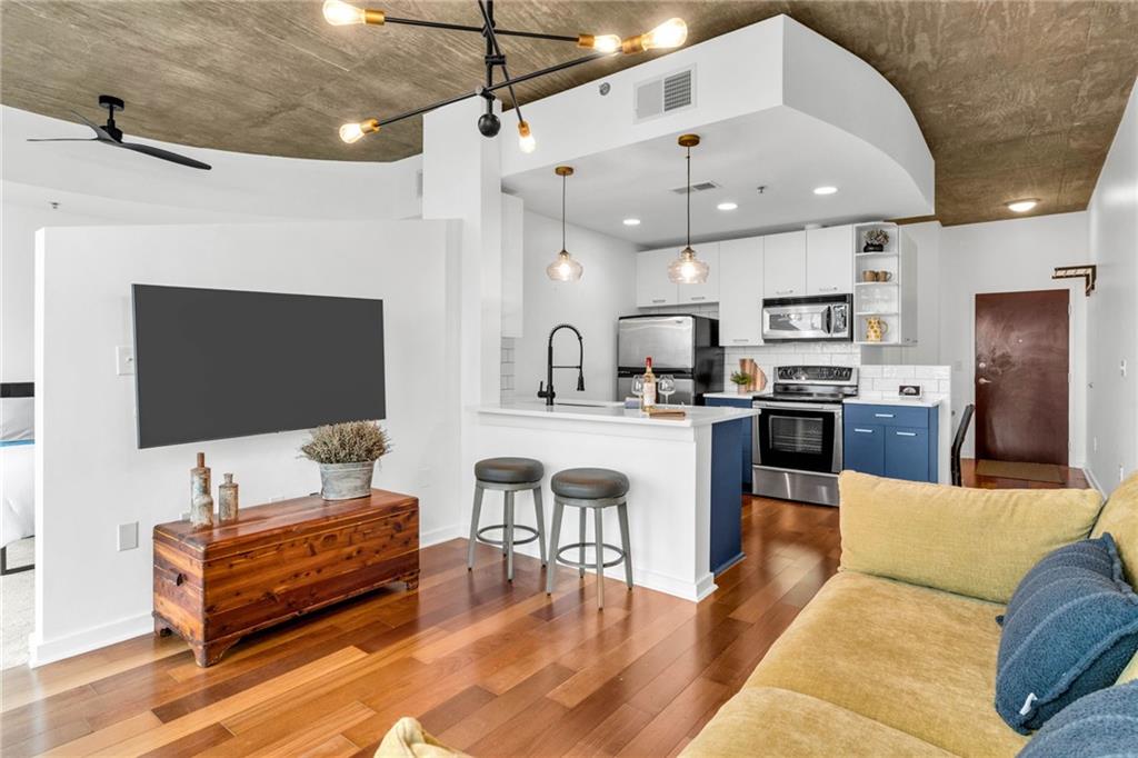 3324 Peachtree Road Northeast, Unit 1813 Atlanta, GA 30326 - Photo 6 of 34 a living room with furniture kitchen view and a flat screen tv