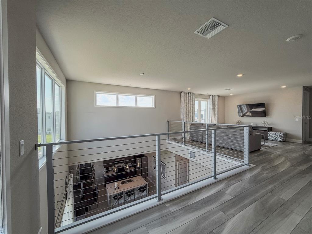 7770 Sandy Ridge Drive, Unit 231 Reunion, FL 34747 - Photo 17 of 25 an empty room with wooden floor kitchen view and windows