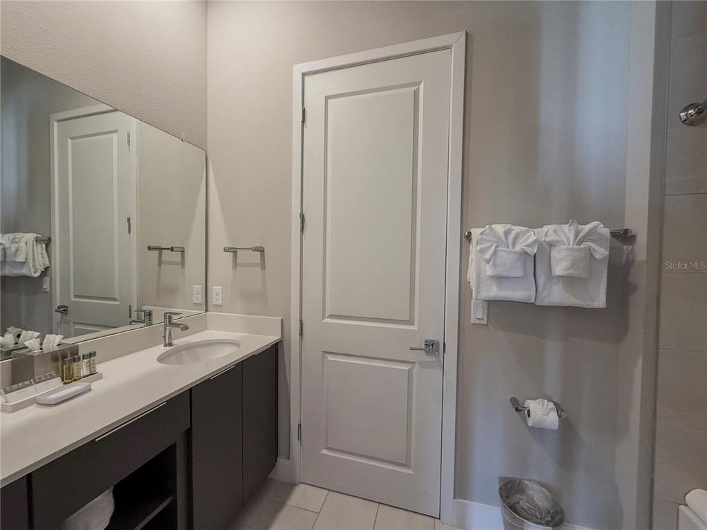 7770 Sandy Ridge Drive, Unit 231 Reunion, FL 34747 - Photo 10 of 25 a bathroom with a granite countertop sink and a mirror