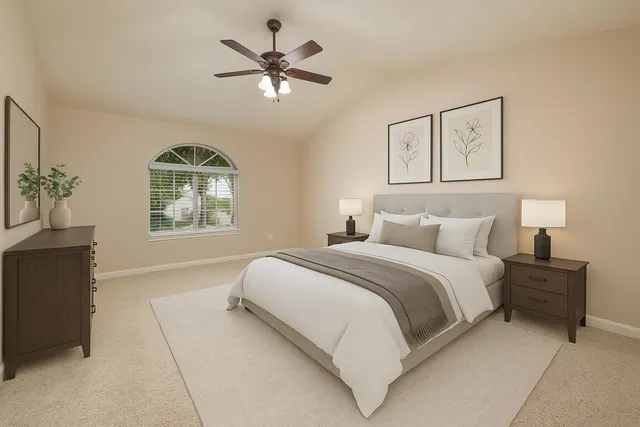 a spacious bedroom with a large bed and a chandelier