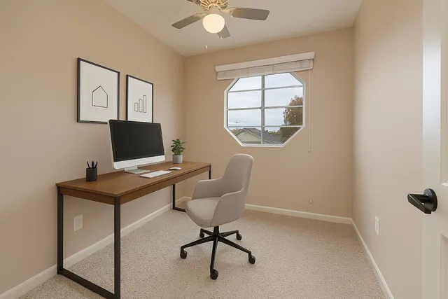 a view of a workspace with furniture and a window