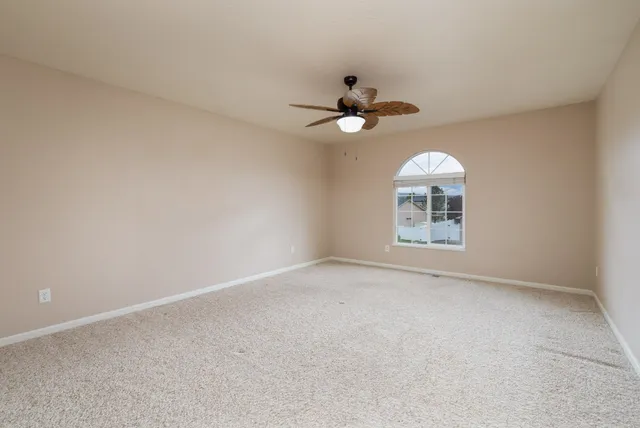 a view of a big room with a chandelier fan and windows