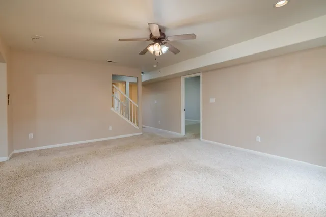a view of an empty room with a ceiling fan