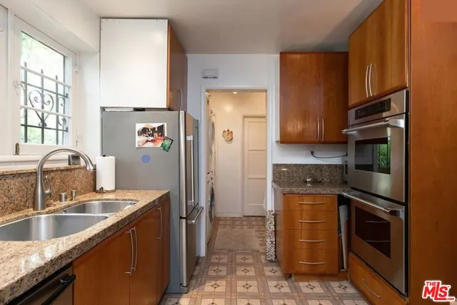 a kitchen with a stove a refrigerator and a stove top oven