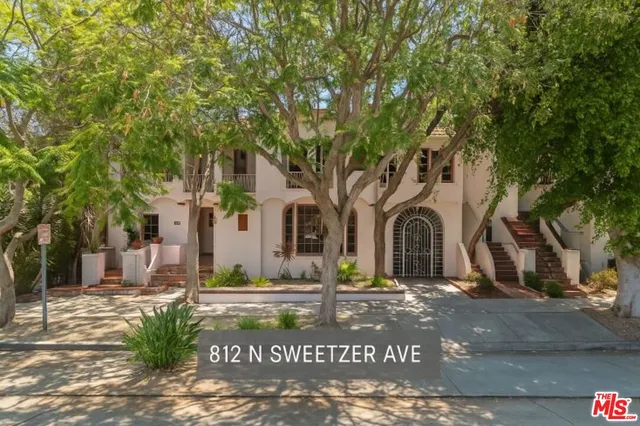 a front view of a house with plants