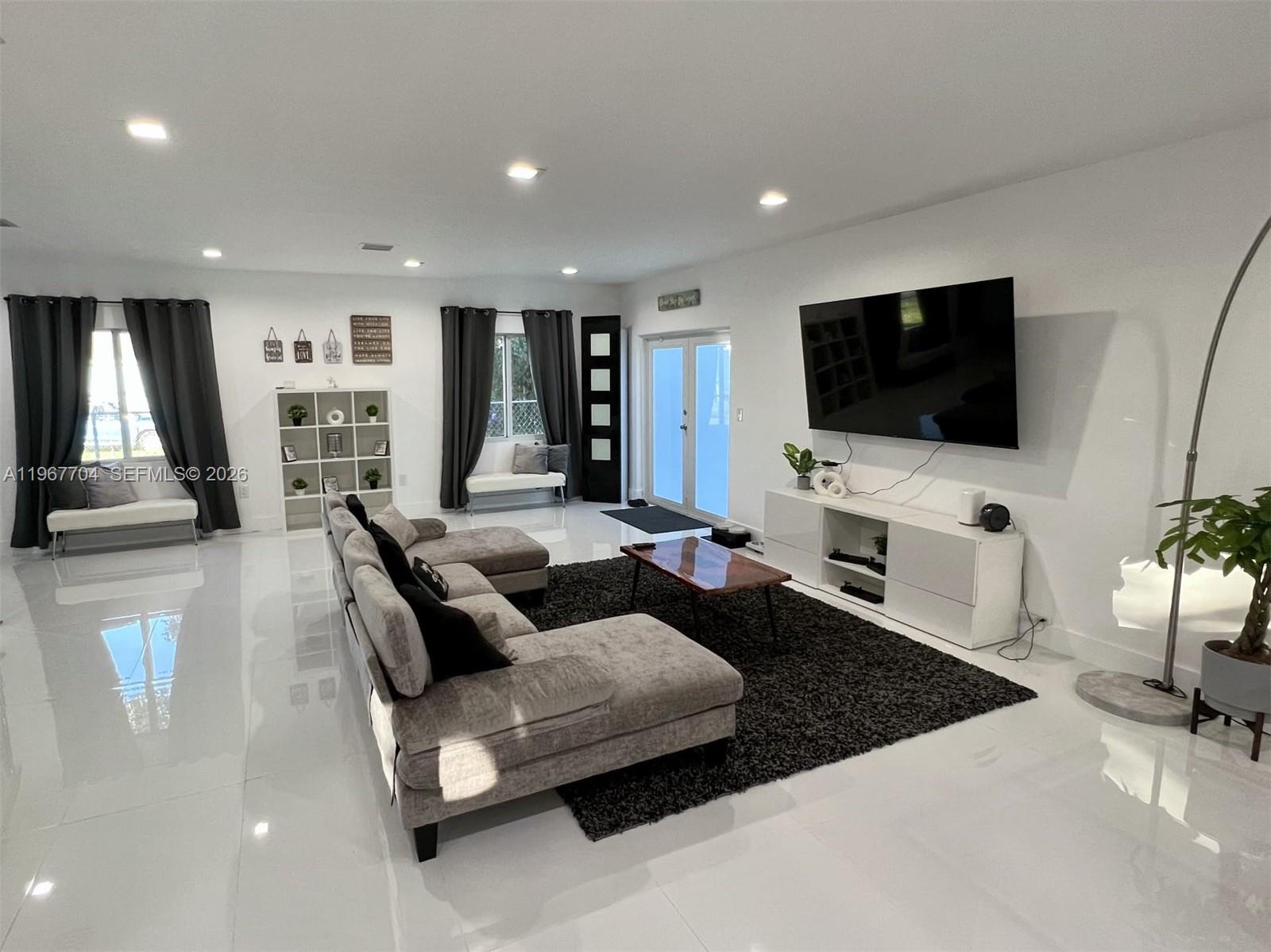 1453 Northwest 70th Street Miami, FL 33147 - Photo 1 of 19 a living room with furniture and a flat screen tv