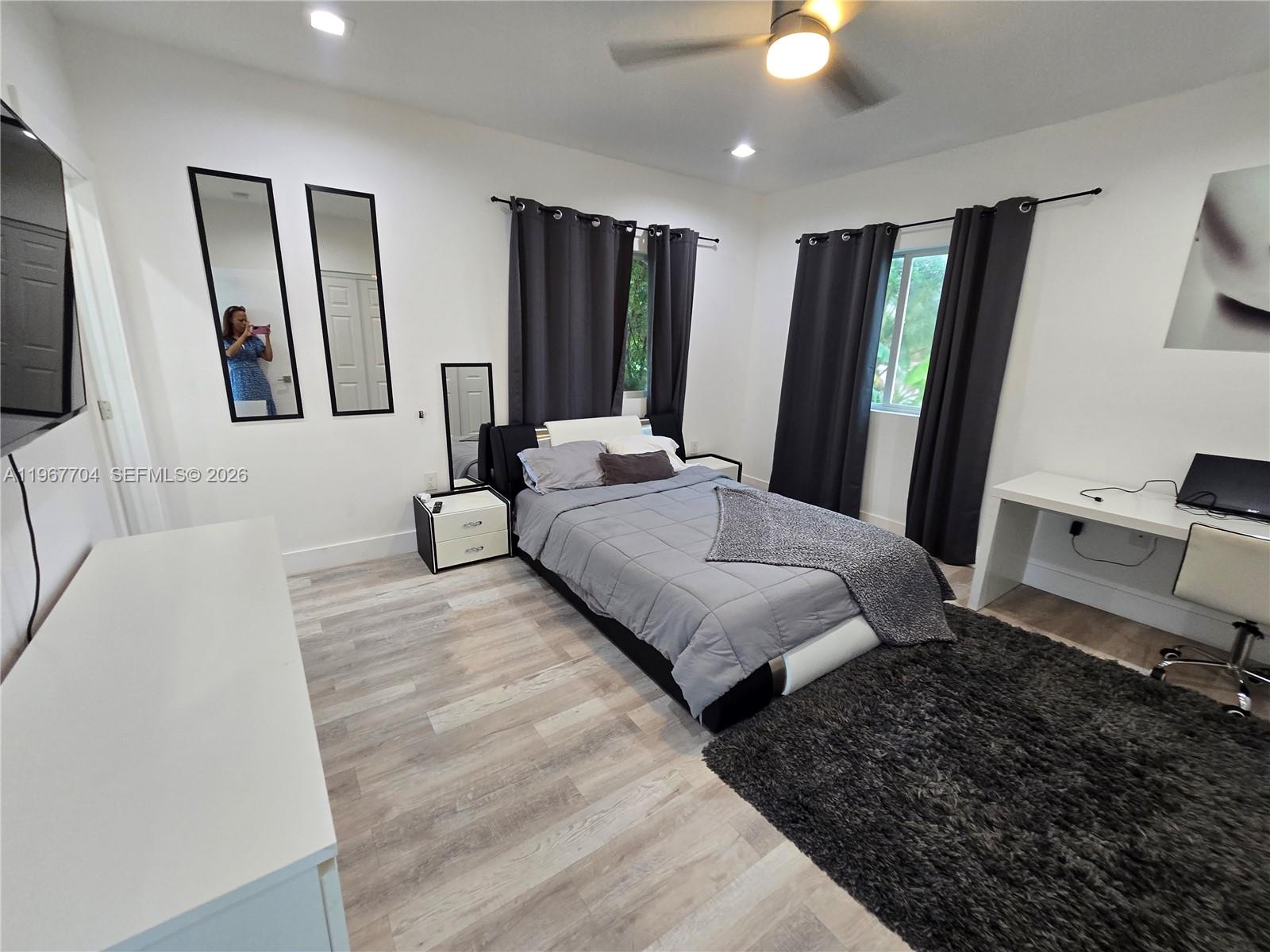1453 Northwest 70th Street Miami, FL 33147 - Photo 11 of 19 a spacious bedroom with a large bed and a flat tv screen