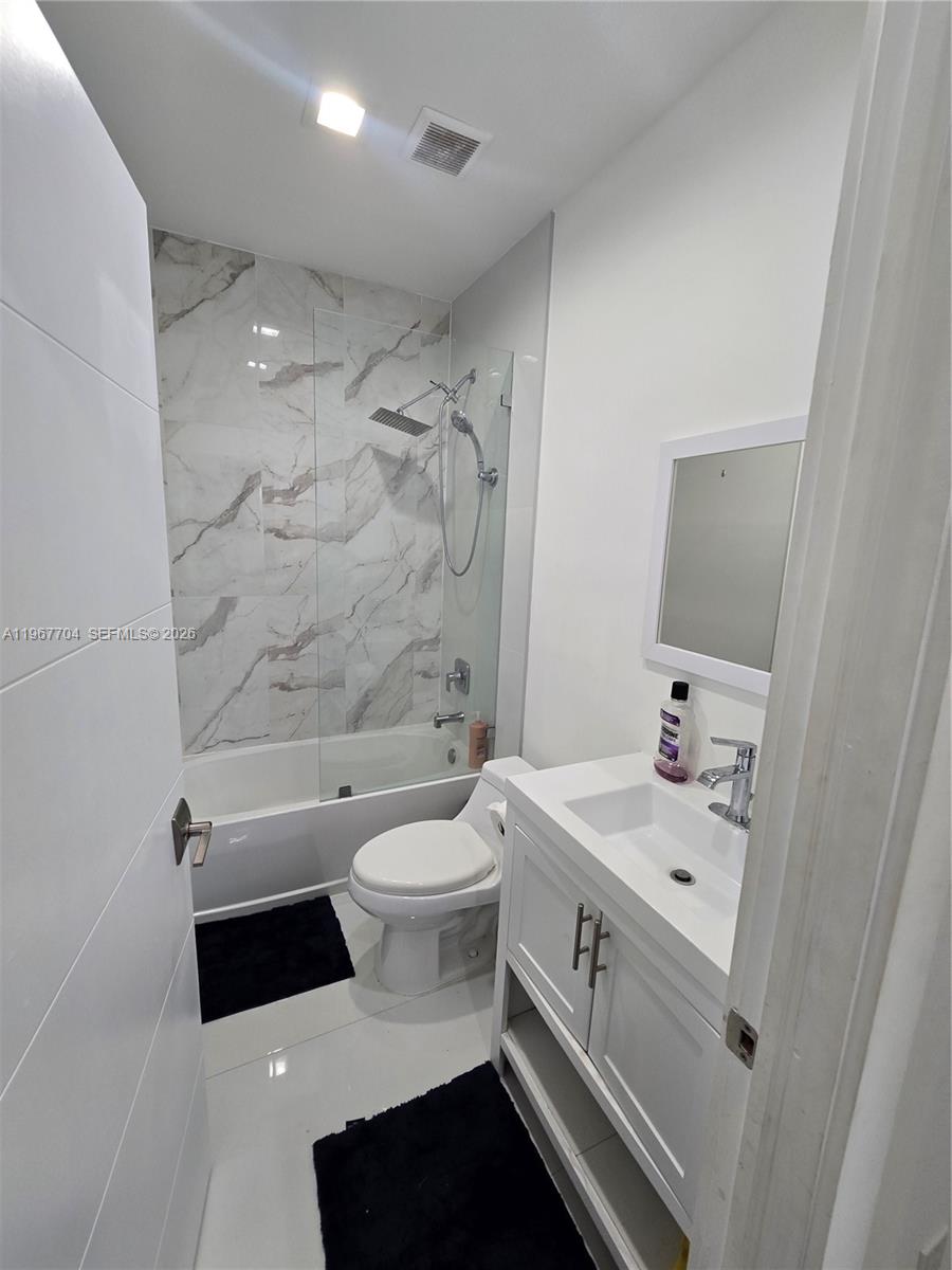 1453 Northwest 70th Street Miami, FL 33147 - Photo 13 of 19 a bathroom with a sink a toilet and a bathtub