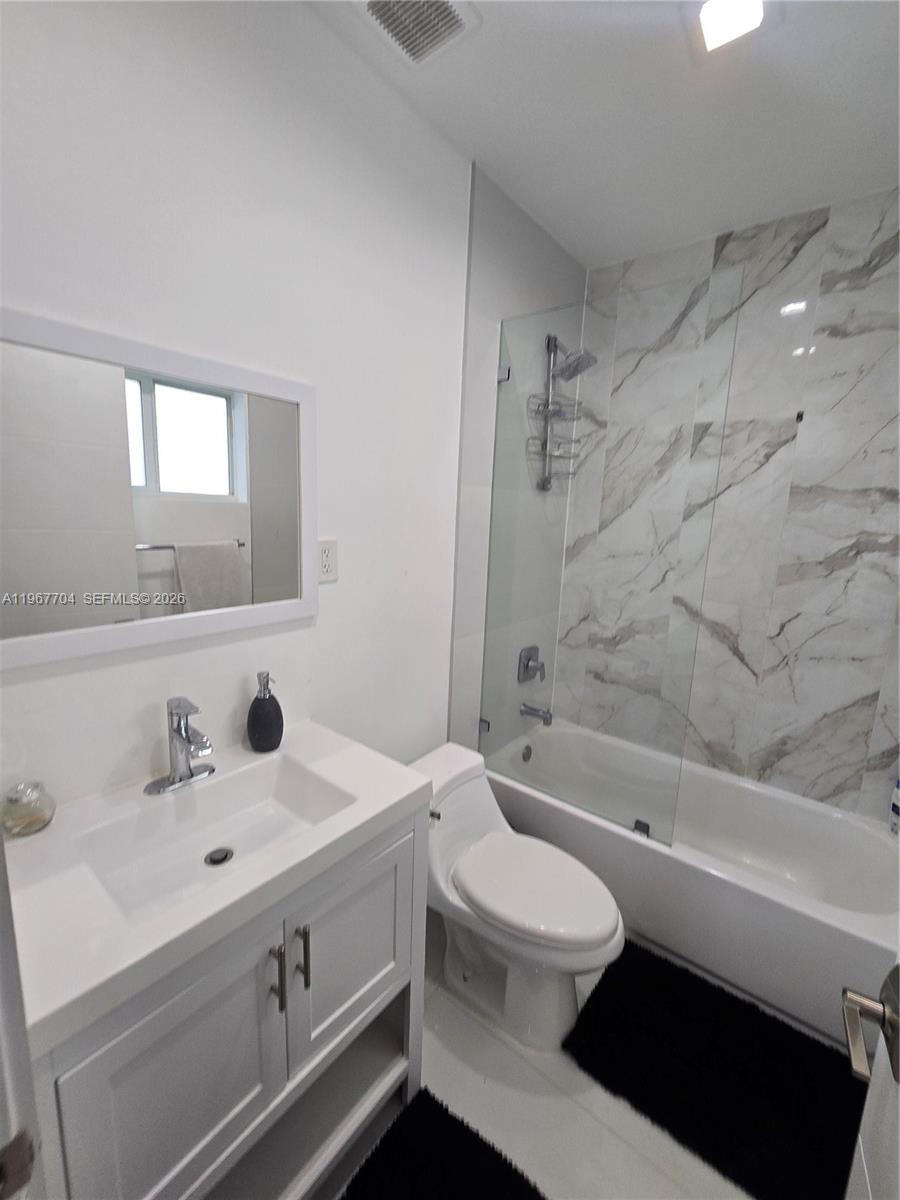 1453 Northwest 70th Street Miami, FL 33147 - Photo 15 of 19 a bathroom with a sink a toilet and a bathtub