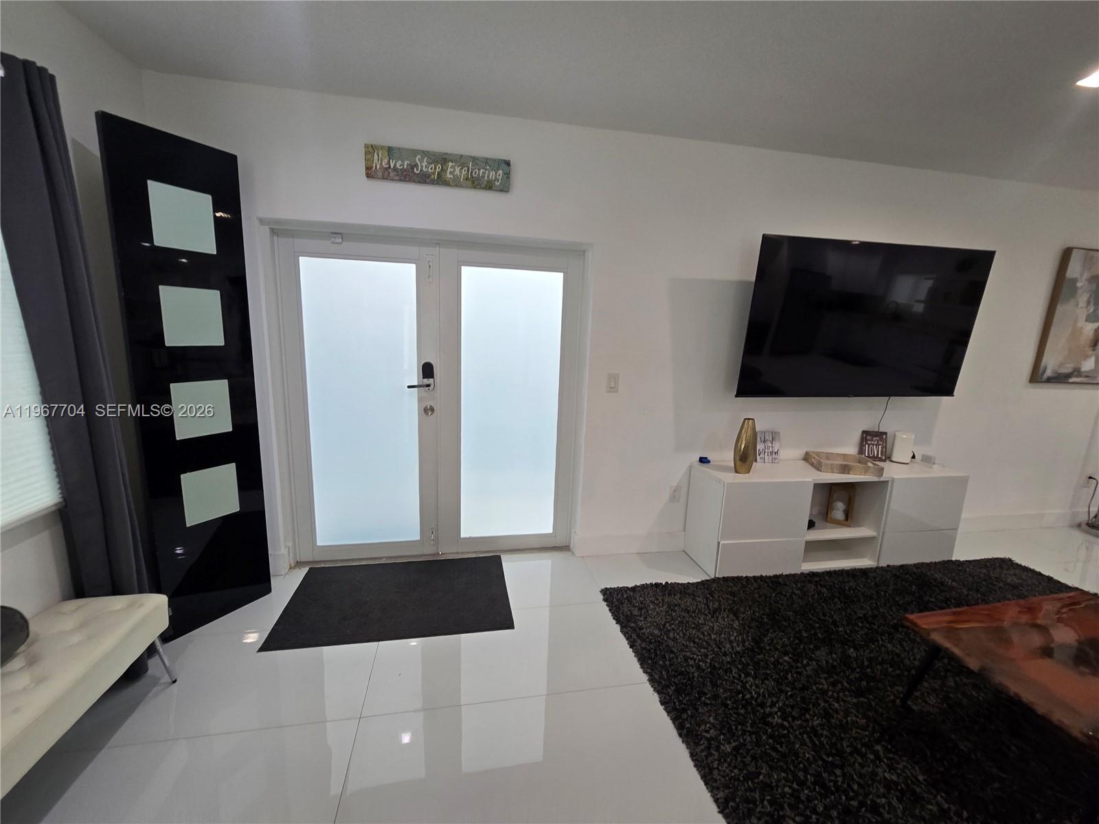 1453 Northwest 70th Street Miami, FL 33147 - Photo 17 of 19 a living room with a couch and a flat screen tv