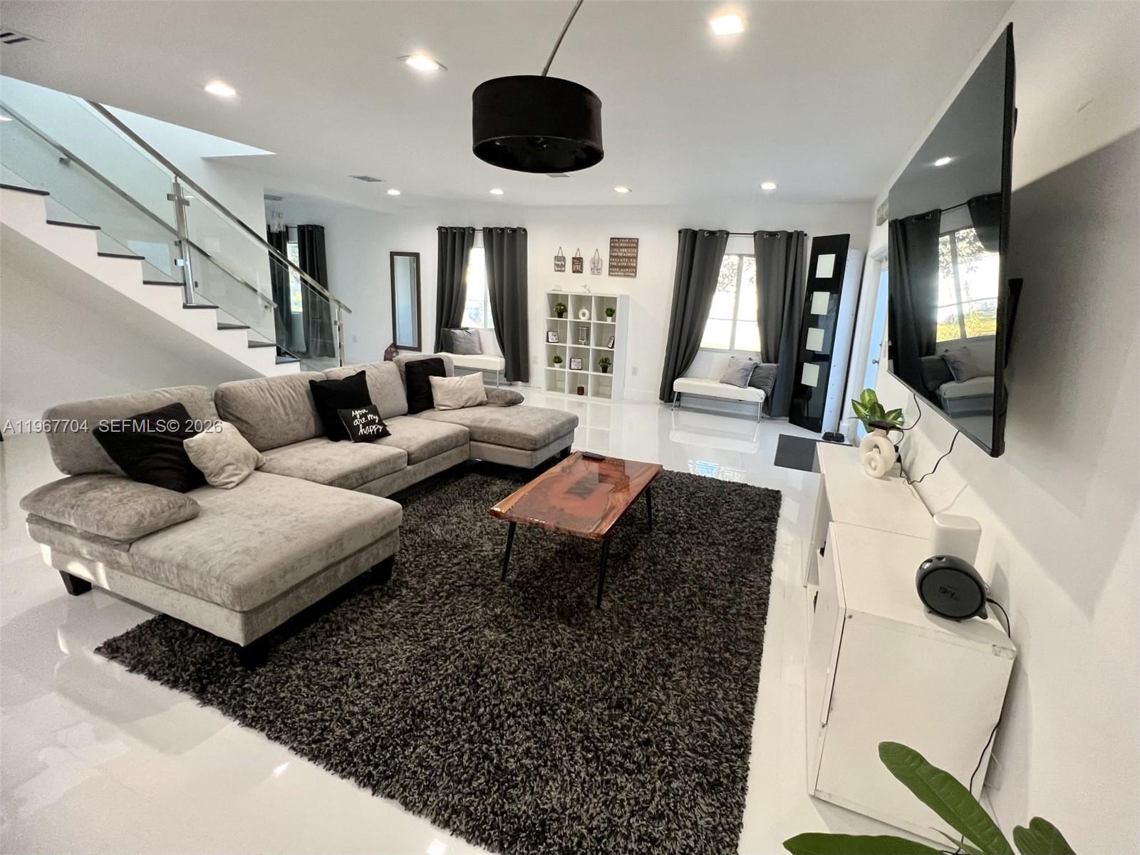 1453 Northwest 70th Street Miami, FL 33147 - Photo 2 of 19 a living room with furniture and a flat screen tv