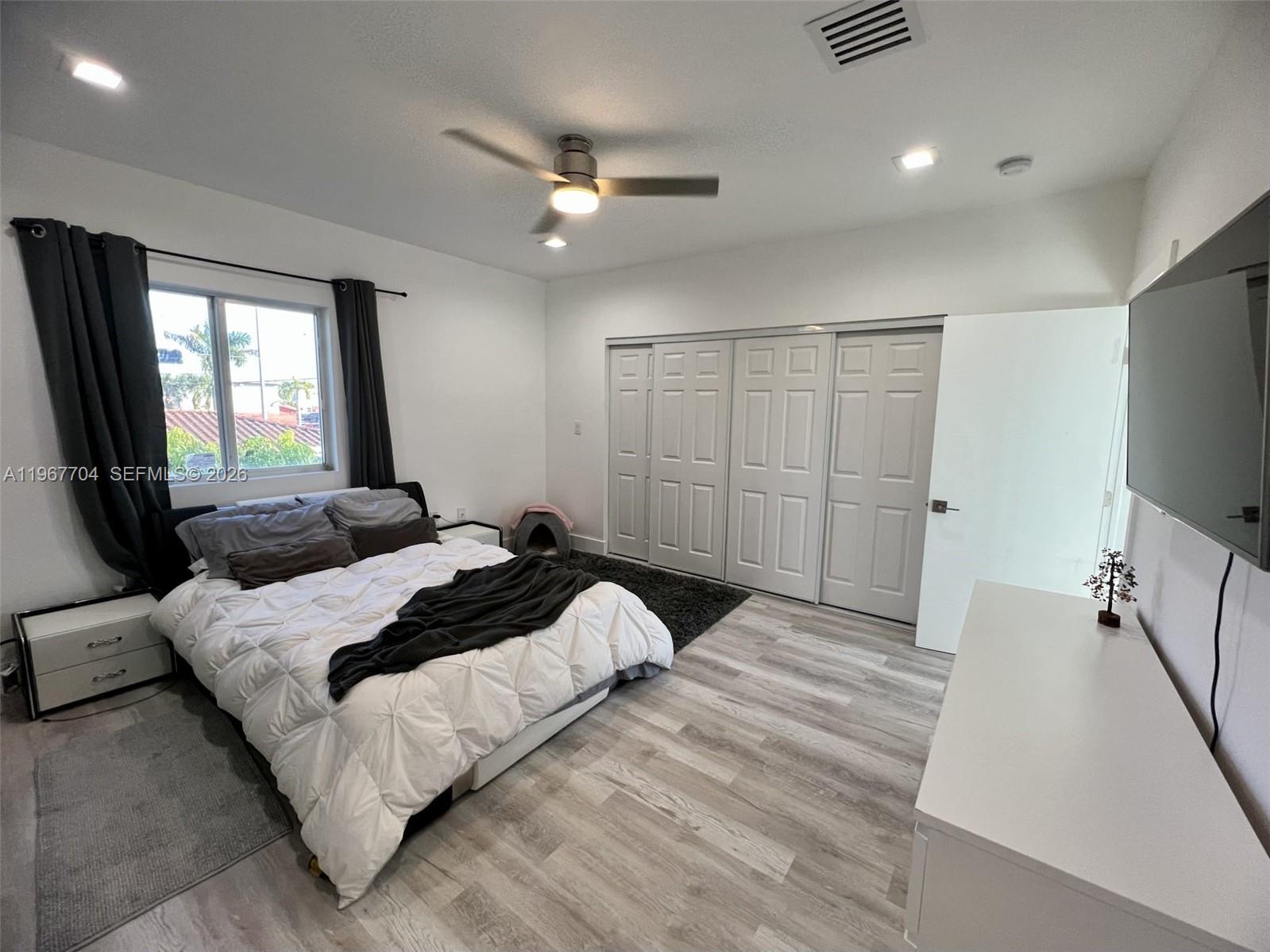 1453 Northwest 70th Street Miami, FL 33147 - Photo 5 of 19 a bedroom with a large bed and a flat tv screen on dresser