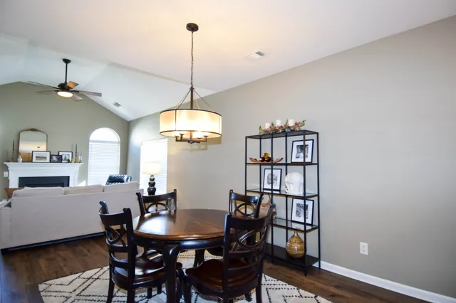 a kitchen with stainless steel appliances granite countertop a refrigerator a stove and a sink with wooden floor