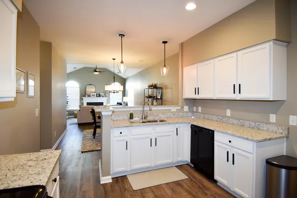 a view of a kitchen with kitchen island a counter top a sink and refrigerator