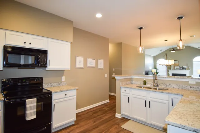 a kitchen with sink cabinets and wooden floor