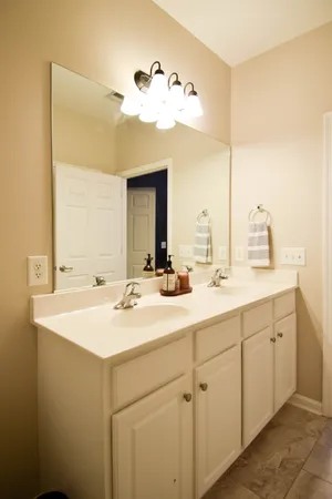 a bathroom with a double vanity sink toilet and shower