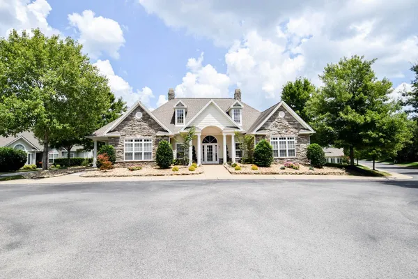 a front view of a house with a yard and trees