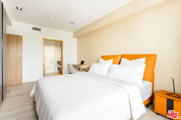 a bedroom with a bed and blue countertop with chair